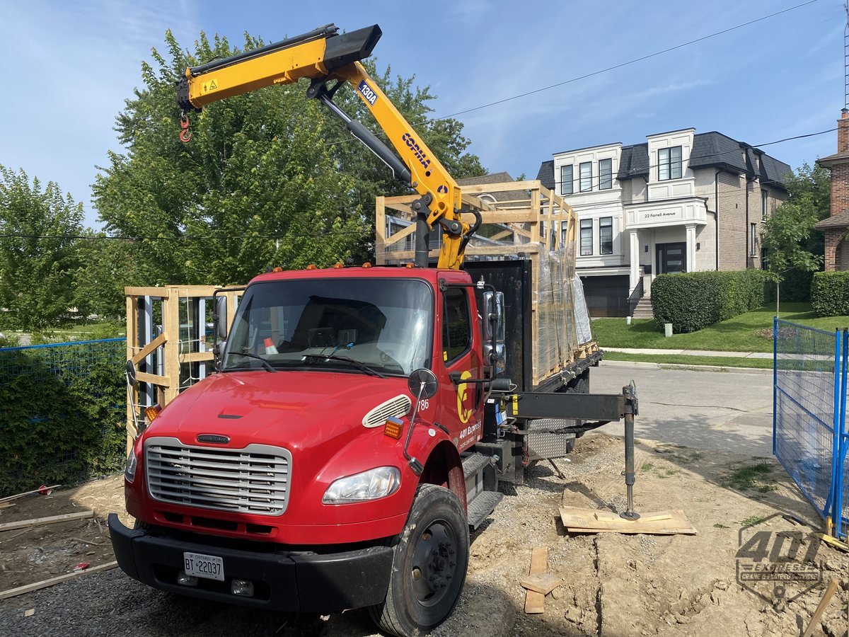 401 Express boom truck with the crane extended over a residential construction site in the GTA
