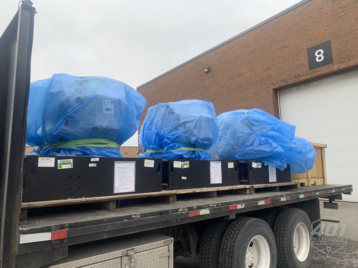Wrapped and crated HVAC units loaded on the 401 Express flatbed at a Toronto loading dock