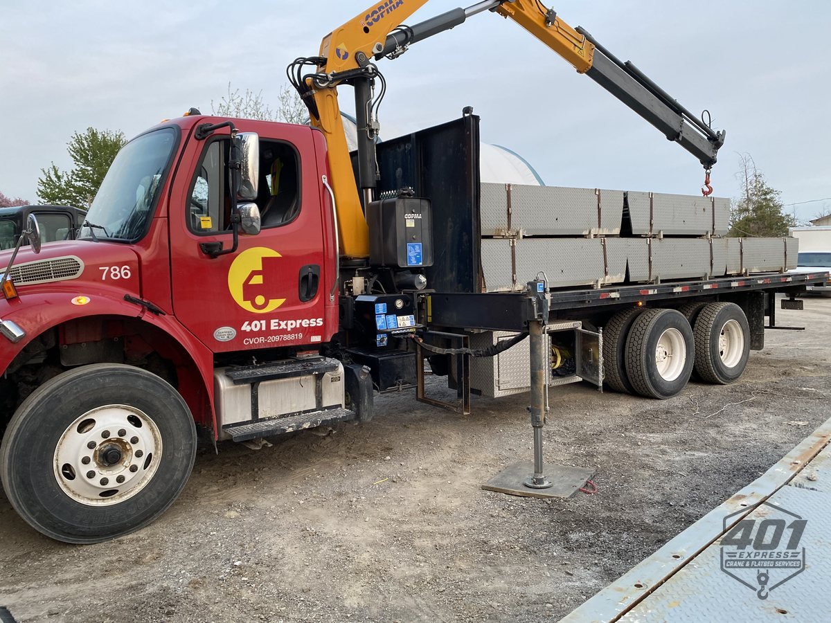 401 Express crane truck loaded with precast concrete slabs, outriggers deployed on a GTA job site