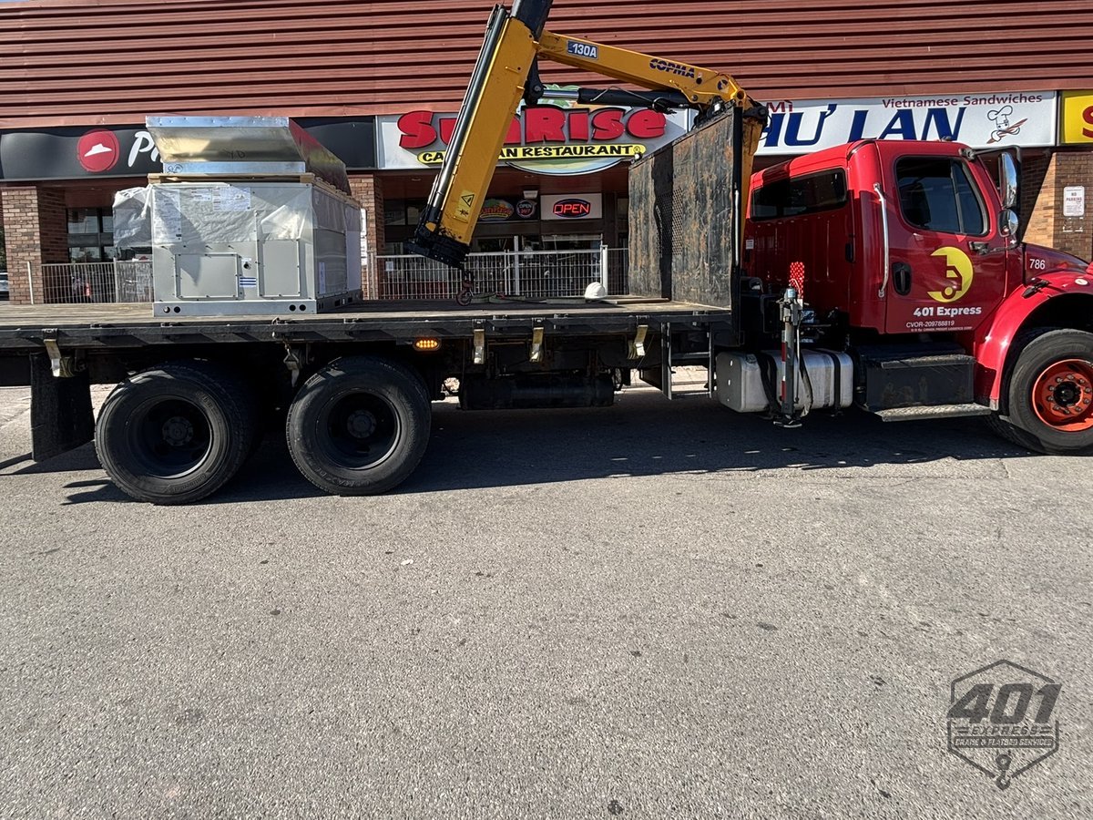 New rooftop HVAC unit shrink-wrapped on the 401 Express flatbed ready to be craned onto a Toronto commercial roof