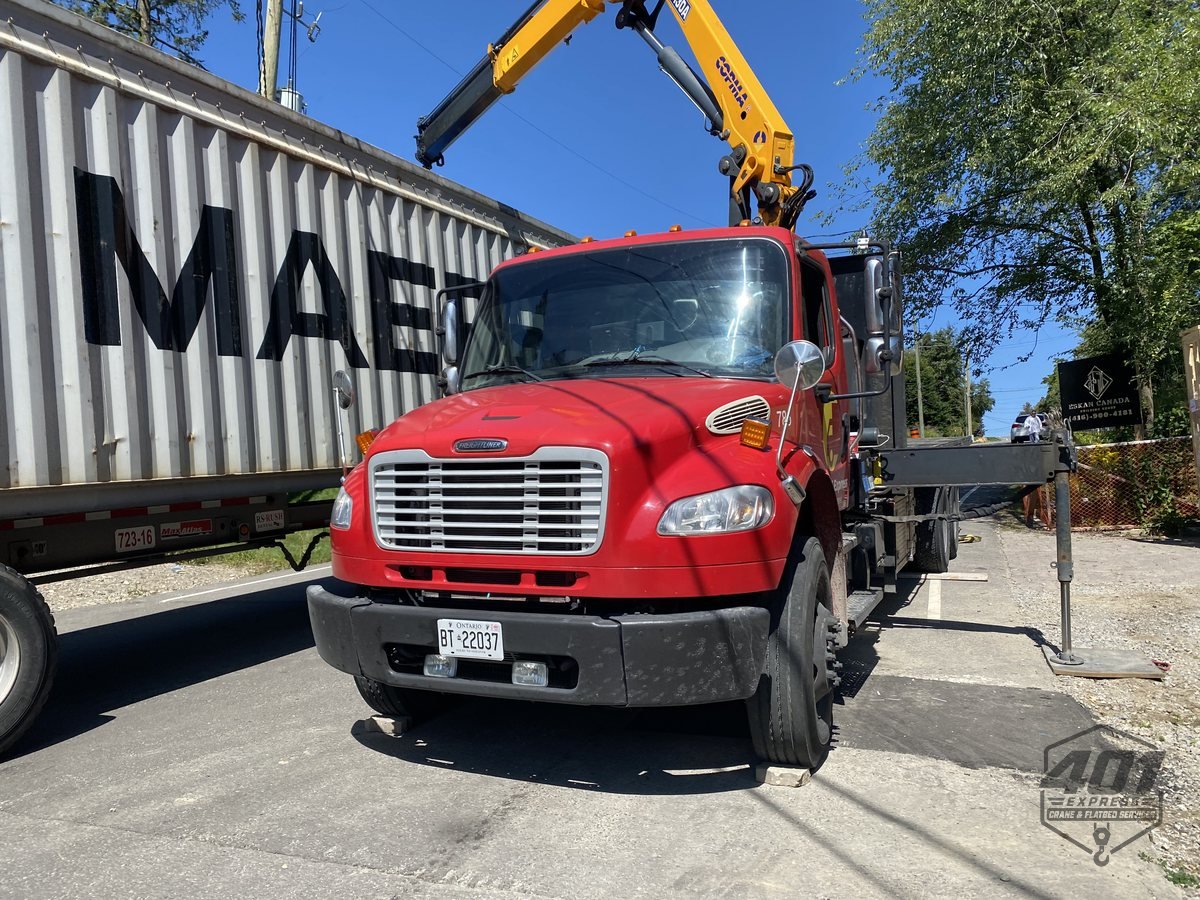 401 Express crane truck positioned alongside a shipping container in the Greater Toronto Area