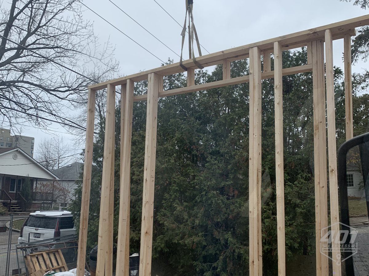401 Express crane lifting a timber wall frame into position on a residential build in Toronto